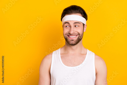 Portrait of attractive cheerful guy sportsman looking aside copy space isolated over bright yellow color background