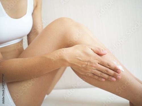 Young woman applying body cream at home. the concept of body lotion and health. closeup photo  blurred.