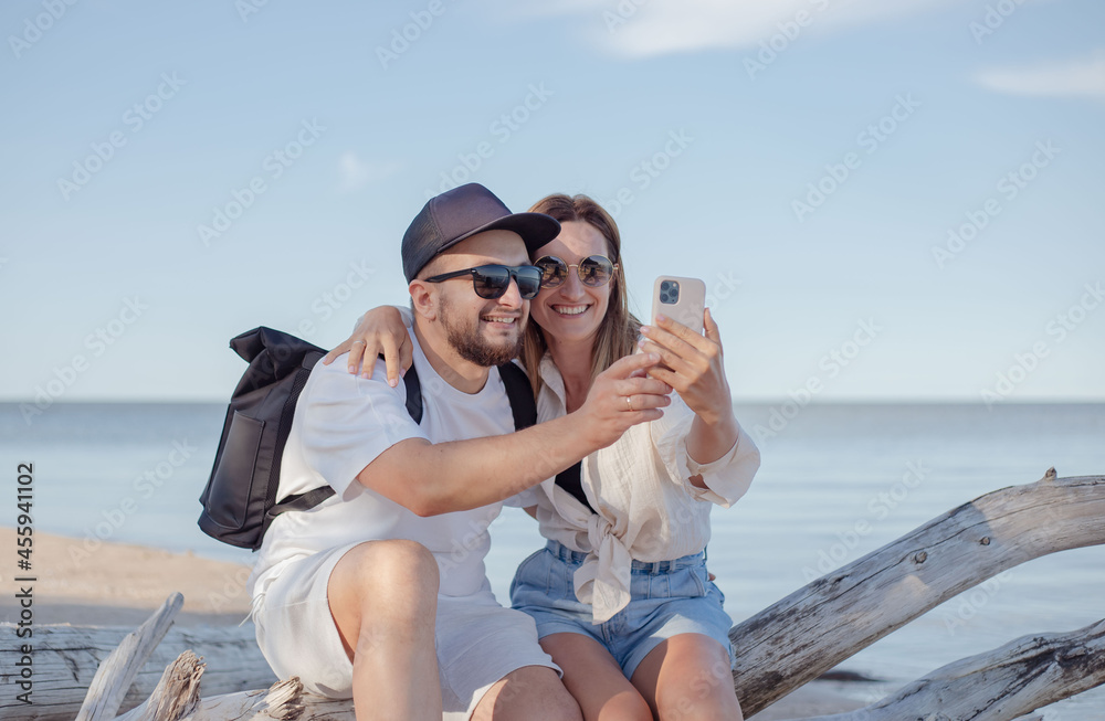Young couple make a selfie by mobile at beach.
