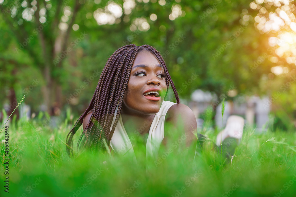 Fototapeta premium Pretty smiling African girl relaxing outdoor