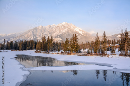Winter landscape, with snow, trees and river passing through the rocky mountains in Canada © Daniel