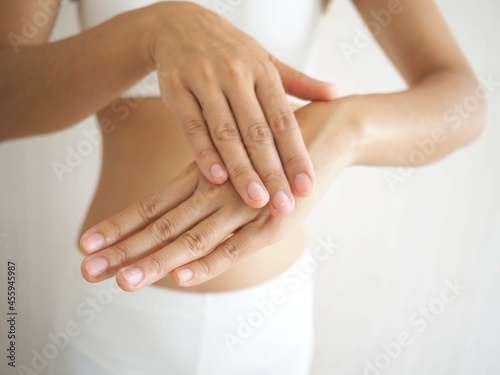 Asian woman's hands applying moisturizing hand-cream. skin cream concept. closeup photo, blurred.
