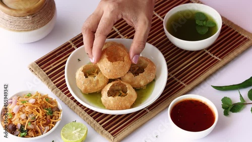 Girl women eating serving Pani puri golgappe with hand Chat item India. North Indian street food Indian panipuri snack 4K footage video tamarind water potato stuffing Delhi Mumbai Holi Diwali Dussehra photo