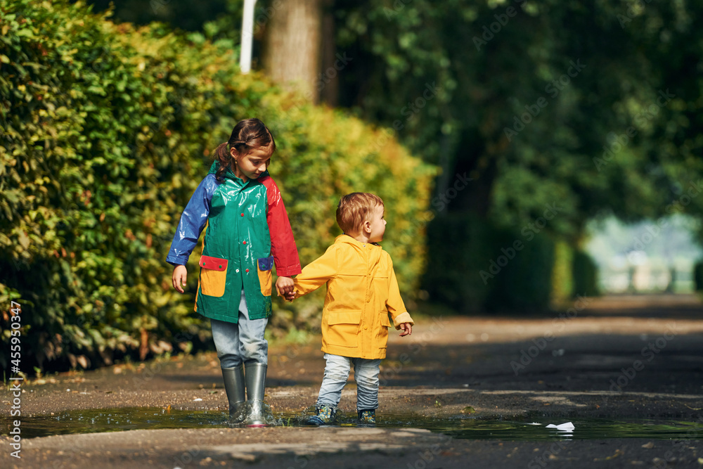 Walking together. Kids having fun outdoors in the park after the rain Walking together. Kids having fun outdoors in the park after the rain