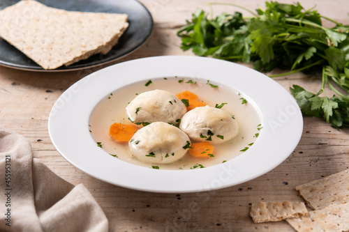 Traditional Jewish matzah ball soup on wooden table	 photo