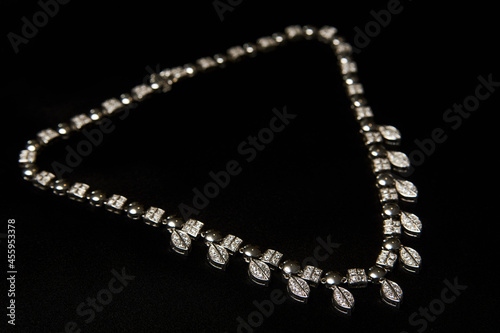 Necklace with diamonds on black background with copy space