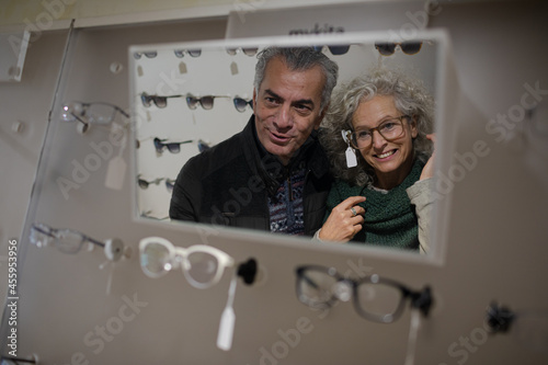 Senior couple trying on eyeglasses in optometry shop