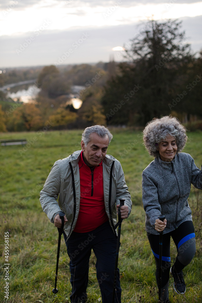 Smiling, affectionate senior couple wih walking sticks Smiling, affectionate senior couple wih walking sticks