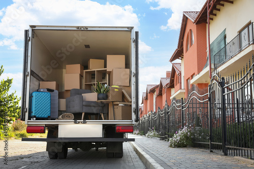 Obraz na plátne Van full of moving boxes and furniture near house