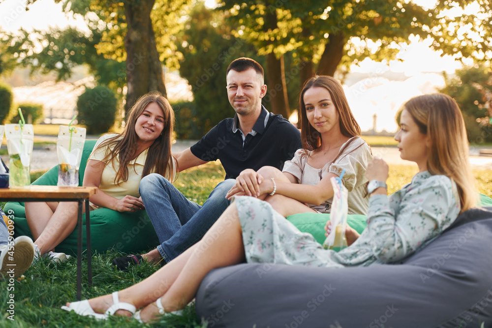 In casual clothes. Group of young people have a party in the park at summer daytime In casual clothes. Group of young people have a party in the park at summer daytime