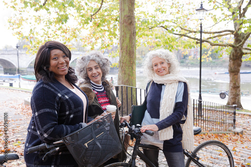 Portrait confident, smiling senior women bike riding in autumn park