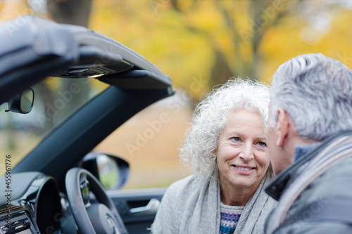Smiling, affectionate senior couple talking in car