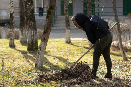 Cleaning of leaves with a rake. Cleaning the area from fallen leaves. © Олег Копьёв