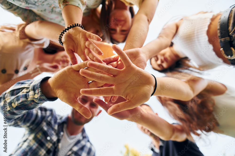View from below of young positive people that looking down View from below of young positive people that looking down