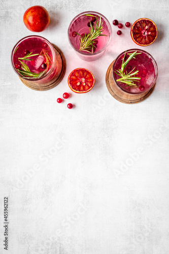 Fototapeta Naklejka Na Ścianę i Meble -  Glasses of cold drink with cranberry and red oranges
