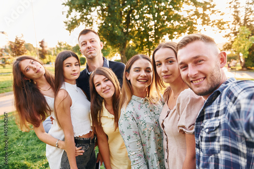 Taking a selfie. Group of young people have a party in the park at summer daytime
