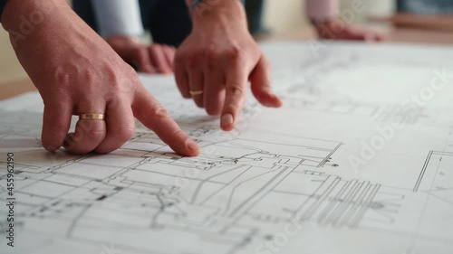 Hands engineers in shot on drawing table. They point their fingers at the blueprint. Engineers team discussing together with blueprint on the drawing table for planning the work in the industrial