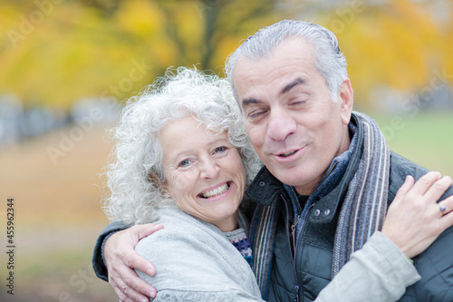 Portrait smiling, affectionate senior couple hugging in park