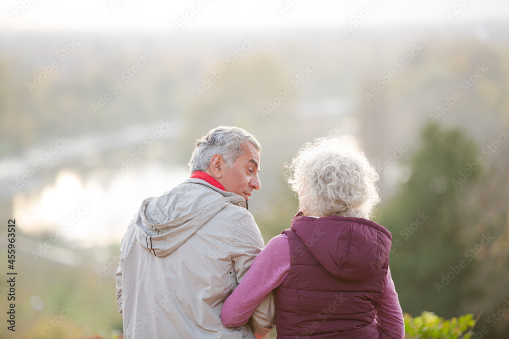 Affectionate active senior couple at autumn park pond