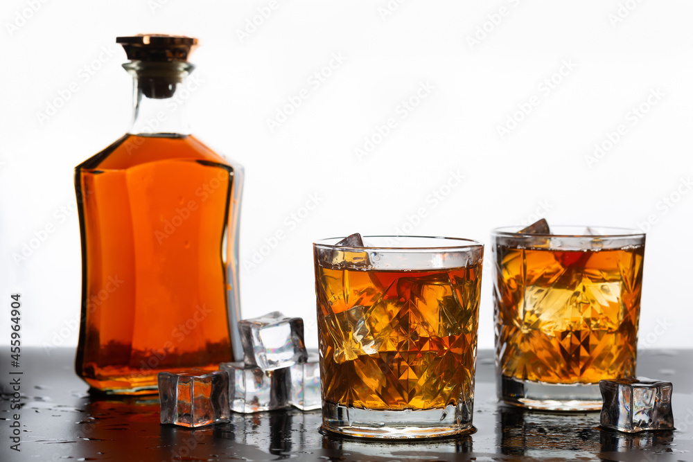 Golden whiskey in glass with ice cubes