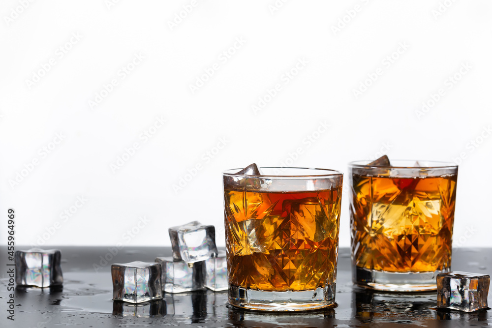 Golden whiskey in glass with ice cubes Golden whiskey in glass with ice cubes