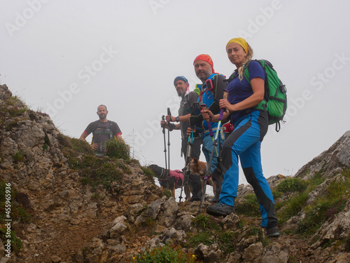 Obraz na plátně A group of hikers with backpacks, hiking in a beautiful mountainous area with th