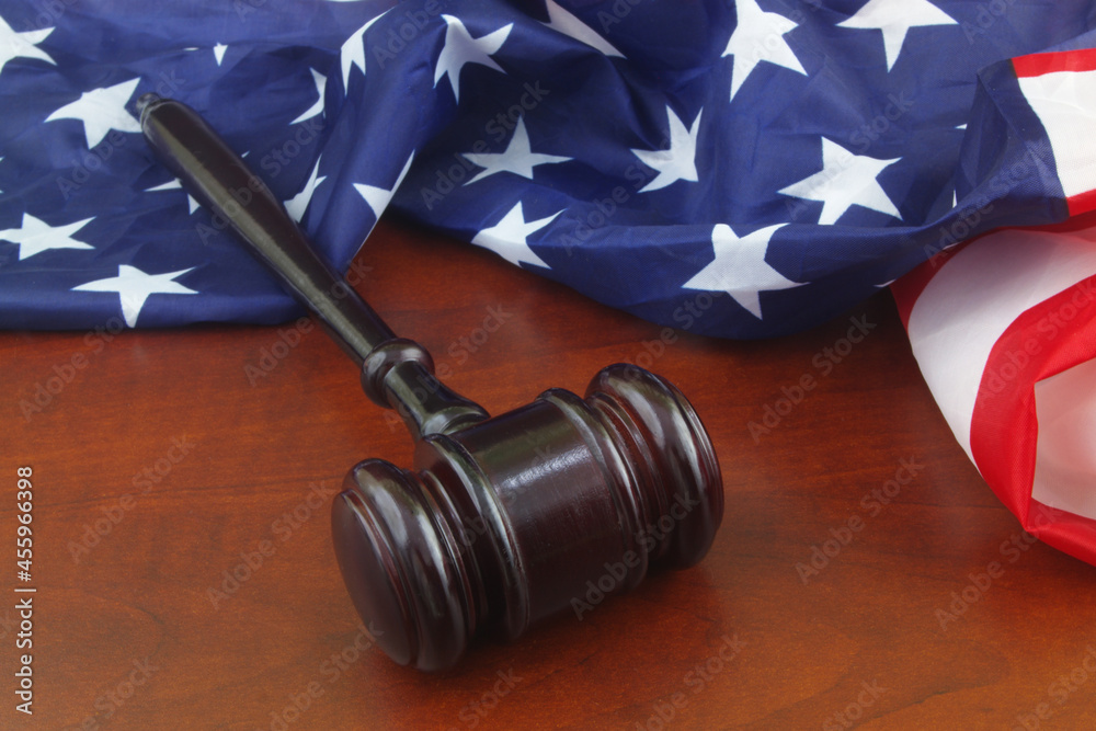 USA laws and court concept. Gavel and flag on United States on wooden background.