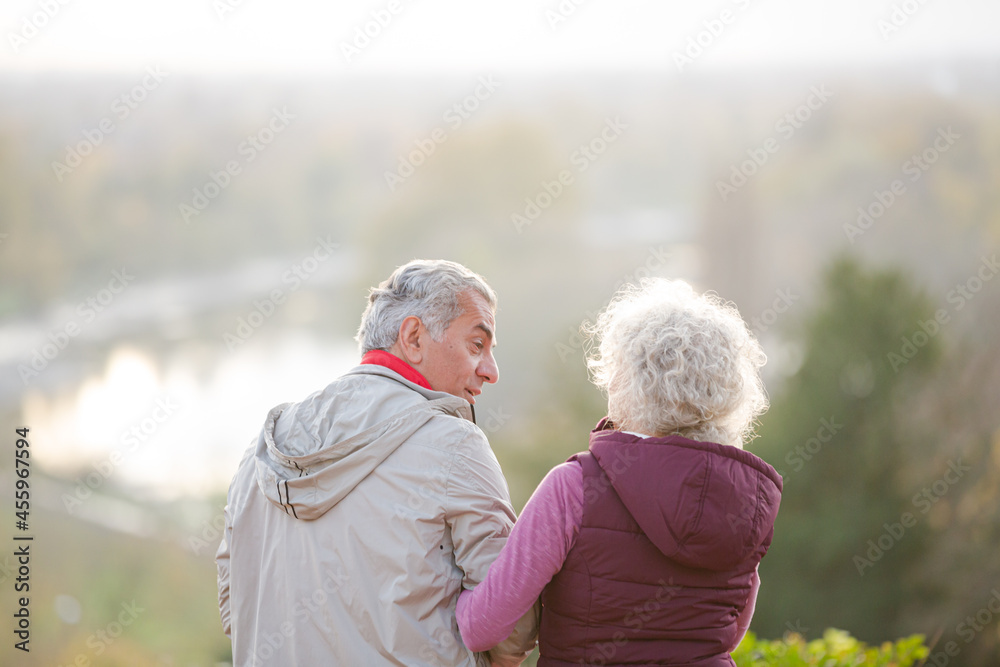 Affectionate active senior couple at autumn park pond
