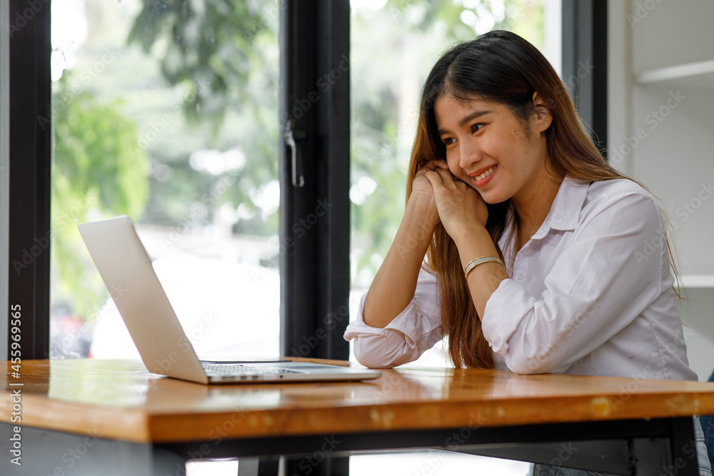 Young asian woman having conference video call using laptop talking to coworker online audience sitting at office desk in evening. Young asian woman having conference video call using laptop talking to coworker online audience sitting at office desk in evening.