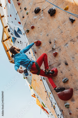 Daily workouts. Young man professional rock climber practicing at training center in sunny day, outdoors. Concept of healthy lifestyle, activity