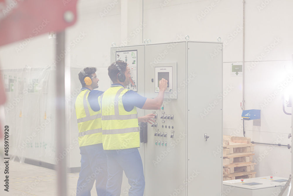Engineers working at control panel in factory Engineers working at control panel in factory