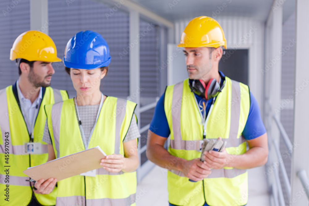 Supervisors and worker with clipboard talking in factory Supervisors and worker with clipboard talking in factory