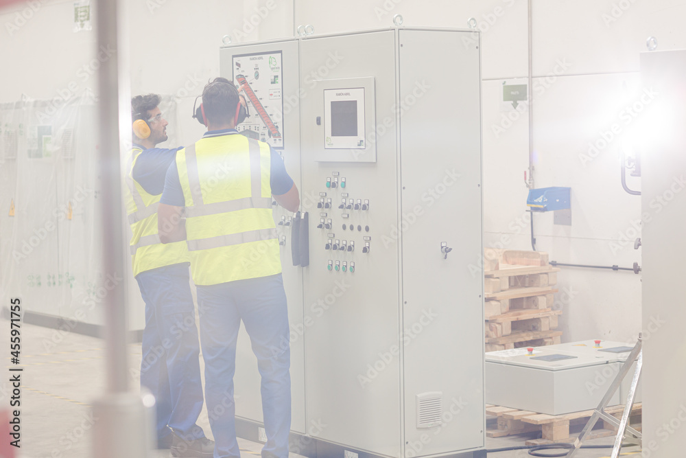 Engineers working at control panel in factory Engineers working at control panel in factory