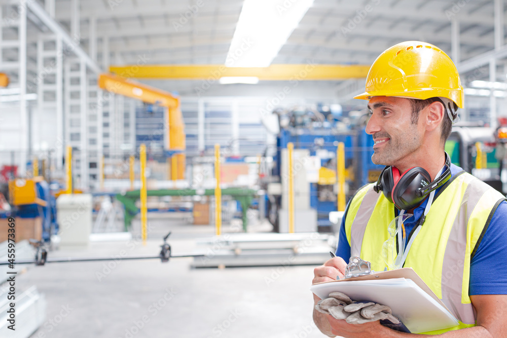 Portrait confident worker with clipboard in steel factory Portrait confident worker with clipboard in steel factory