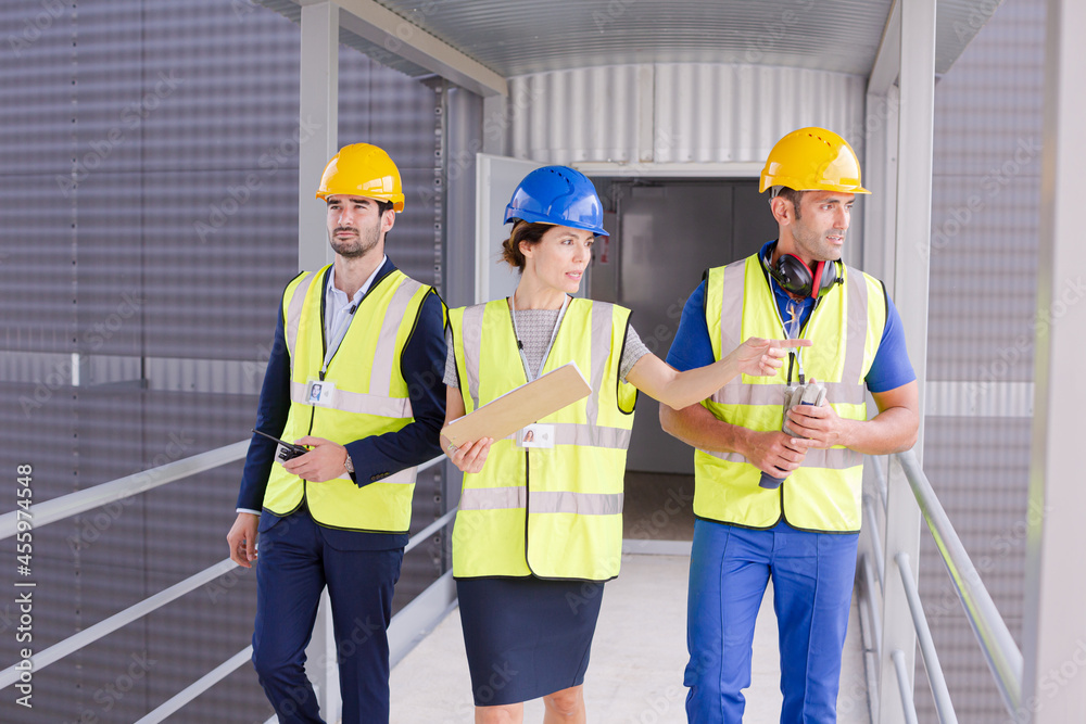 Supervisors and worker with clipboard talking in factory Supervisors and worker with clipboard talking in factory