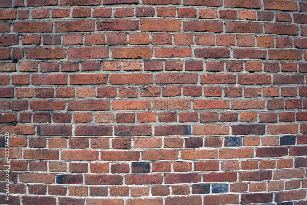 Fragment of a red brick wall with several black bricks. Texture. Background. Fragment of a red brick wall with several black bricks. Texture. Background.