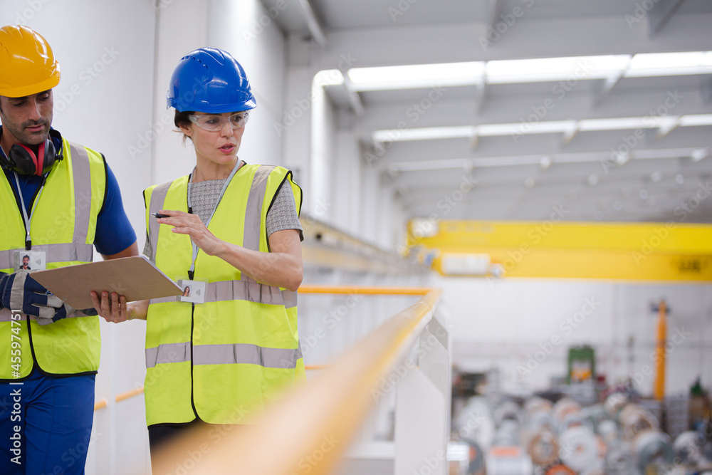 Supervisor and workers with clipboard talking in factory Supervisor and workers with clipboard talking in factory