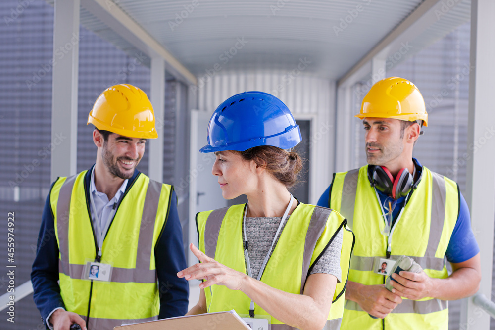 Supervisors and worker with clipboard in factory