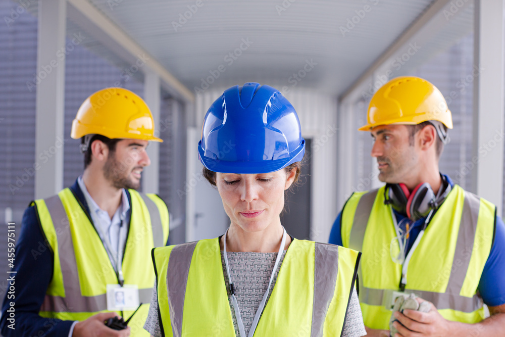 Supervisors and worker with clipboard in factory