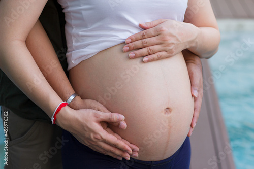 Man holding belly of his pregnant wife . Close up of a pregnant woman.