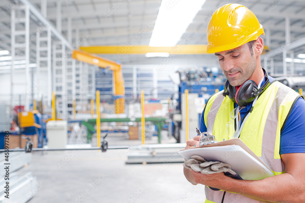 Portrait confident worker with clipboard in steel factory Portrait confident worker with clipboard in steel factory