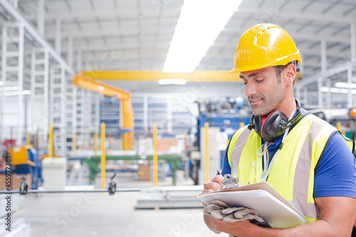 Portrait confident worker with clipboard in steel factory