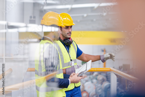 Supervisor and worker talking in steel factory