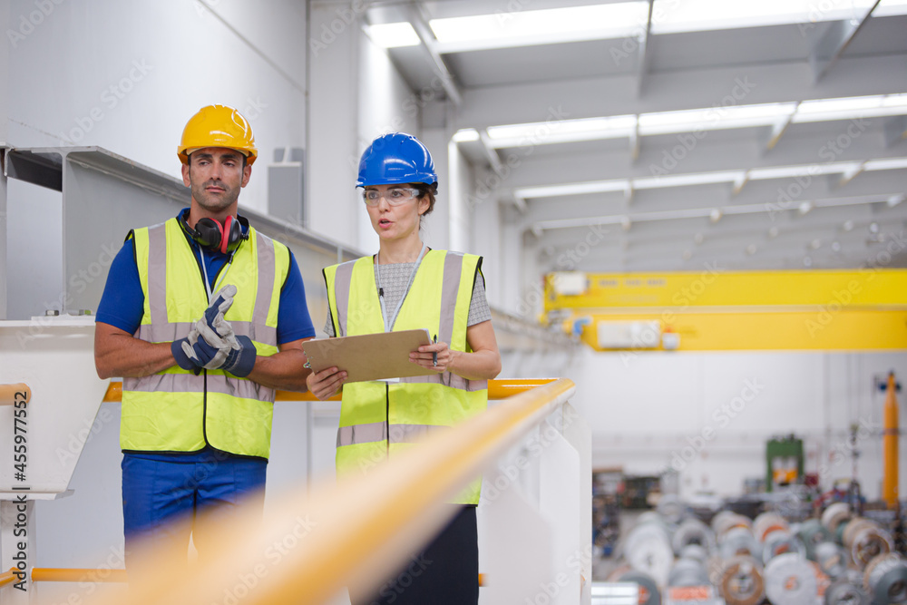 Supervisor and workers with clipboard talking in factory Supervisor and workers with clipboard talking in factory