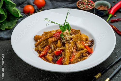 Spicy fragrant eggplant Chinese cuisine on dark stone table photo