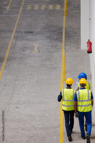 Supervisor and workers walking in factory