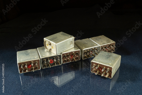 A group of white relays on a table with a reflection