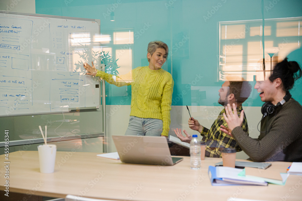 Obraz premium Woman standing at whiteboard, leading conference room meeting