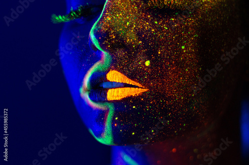 UV light portrait woman with golden powder and glowing fluorescent lines