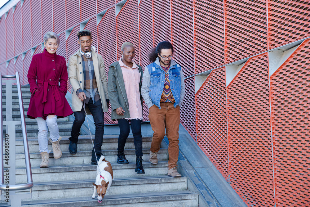 Fototapeta premium Young friends walking down down urban, modern stairs